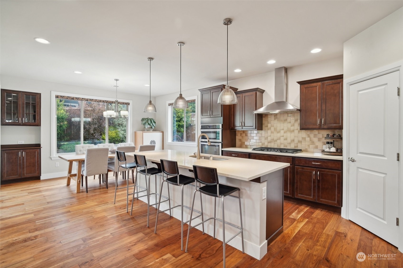 4111 Strumme Road Bothell, WA 98012 - Photo 7 of 39 a open kitchen with stainless steel appliances granite countertop a stove top oven a sink dishwasher a dining table and chairs with wooden floor