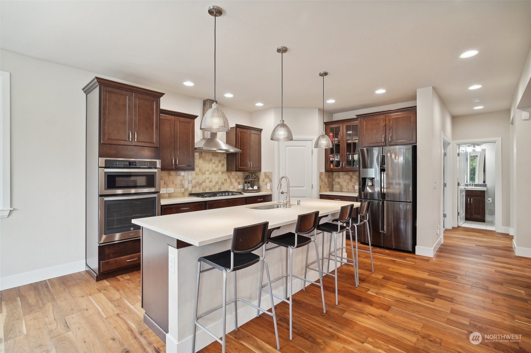 4111 Strumme Road Bothell, WA 98012 - Photo 8 of 39 a kitchen with stainless steel appliances kitchen island granite countertop a stove a refrigerator and a wooden cabinets