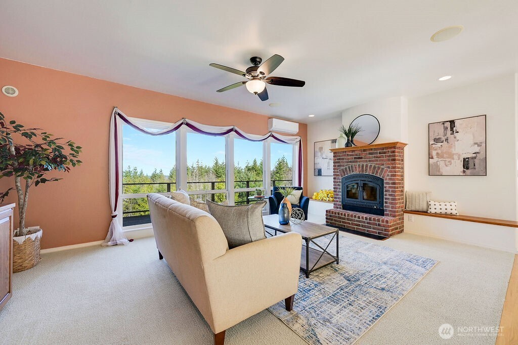 275404 Highway 101 Sequim, WA 98382 - Photo 14 of 40 a living room with furniture a fireplace and a potted plant
