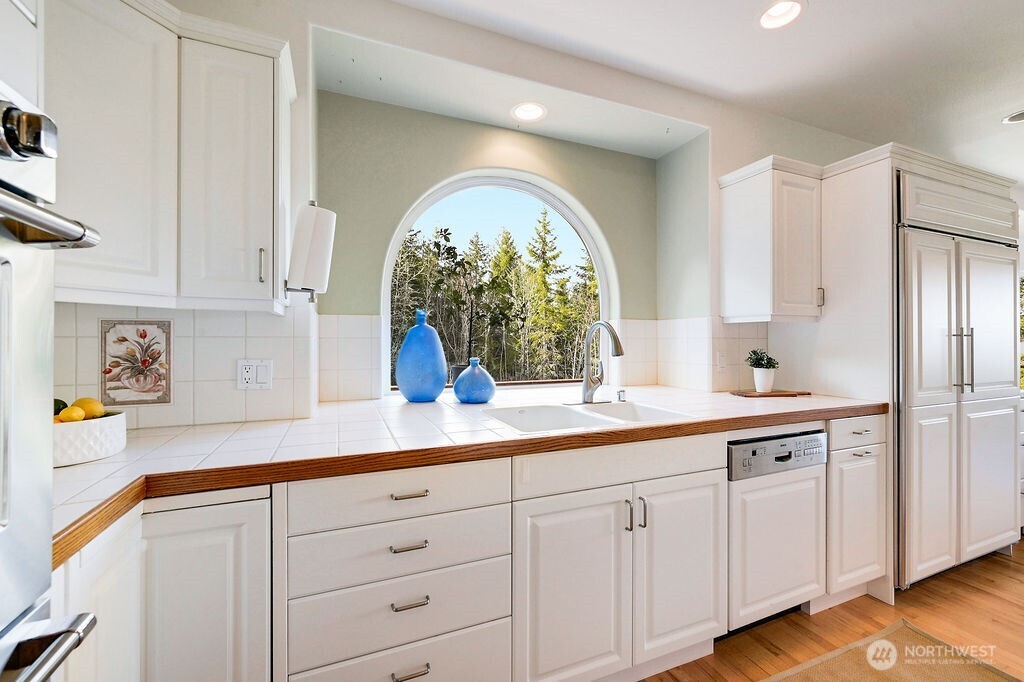 275404 Highway 101 Sequim, WA 98382 - Photo 20 of 40 a kitchen with white cabinets and a large window