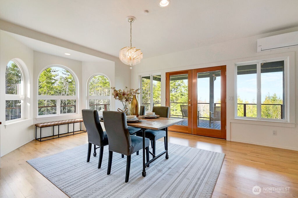 275404 Highway 101 Sequim, WA 98382 - Photo 22 of 40 a view of a dining room with furniture a chandelier and wooden floor