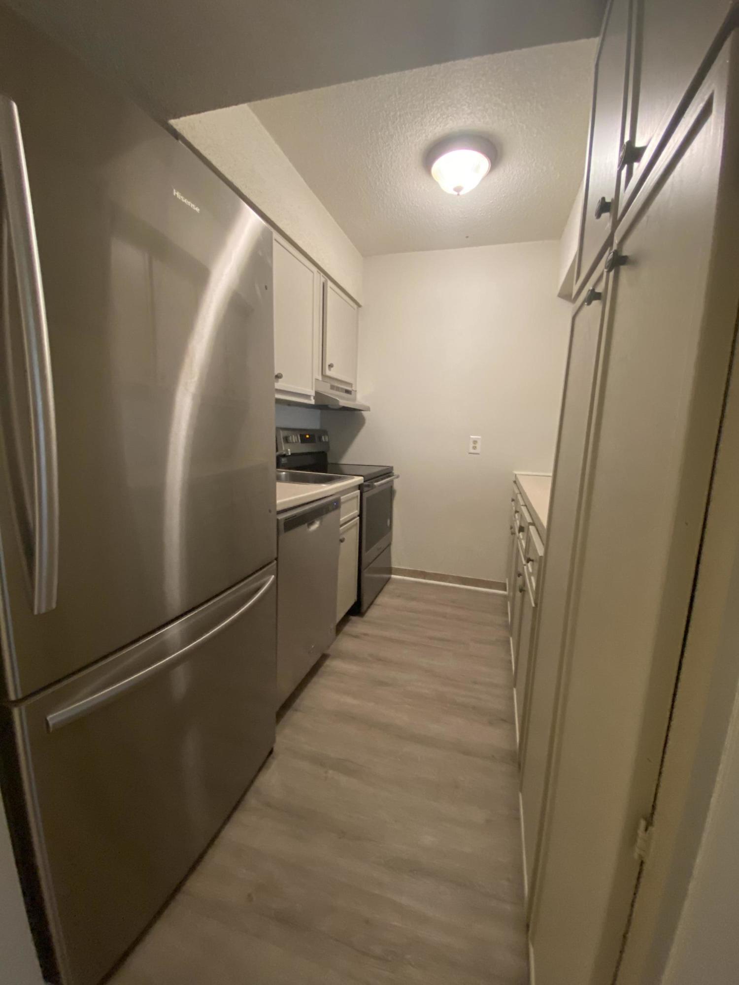 210 Pelham Road, Unit 107C Fort Walton Beach, FL 32547 - Photo 3 of 17 a view of a refrigerator in kitchen and wooden floor