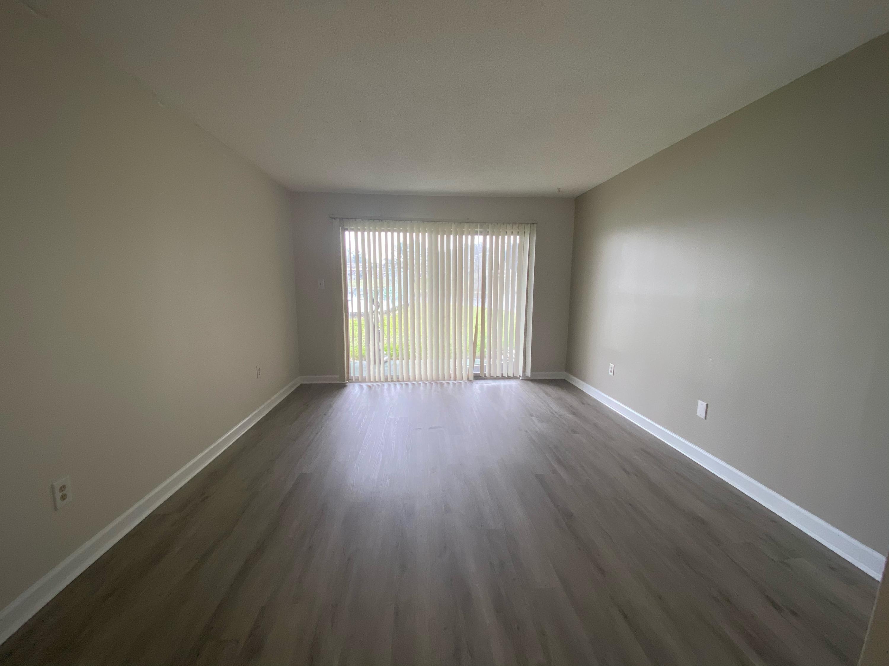 210 Pelham Road, Unit 107C Fort Walton Beach, FL 32547 - Photo 5 of 17 an empty room with wooden floor and windows