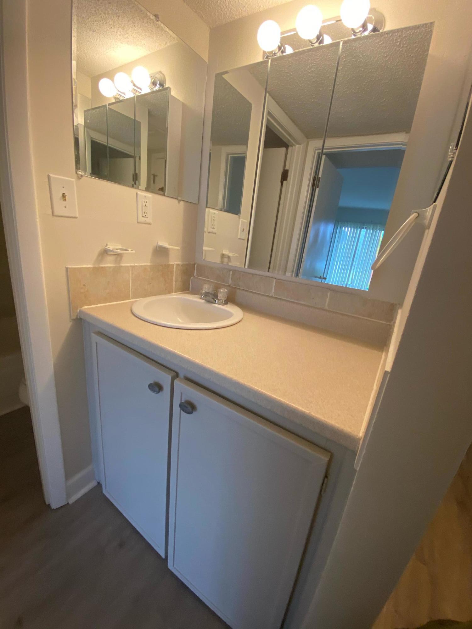 210 Pelham Road, Unit 107C Fort Walton Beach, FL 32547 - Photo 8 of 17 a bathroom with a sink and a mirror