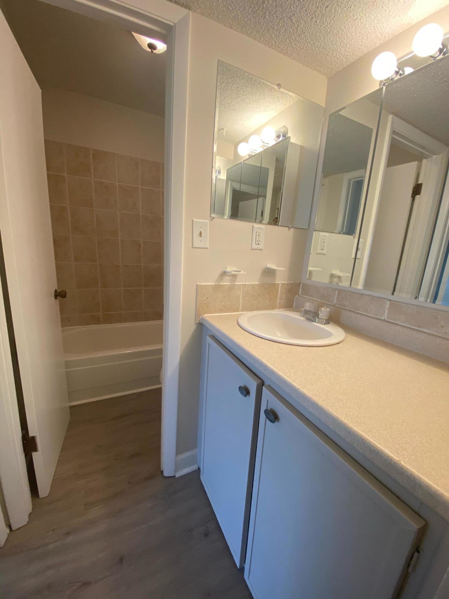 210 Pelham Road, Unit 107C Fort Walton Beach, FL 32547 - Photo 9 of 17 a bathroom with a sink a mirror and a bathtub