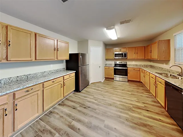 a large kitchen with cabinets stainless steel appliances and a counter space