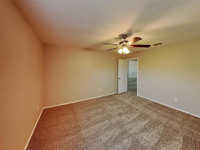 a view of an empty room with a ceiling fan
