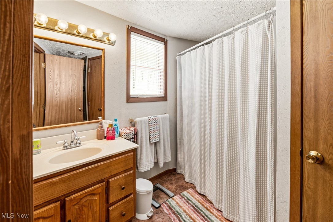 86523 North Bay Road Scio, OH 43988 - Photo 20 of 25 Bathroom featuring a shower with curtain, vanity, and a textured ceiling