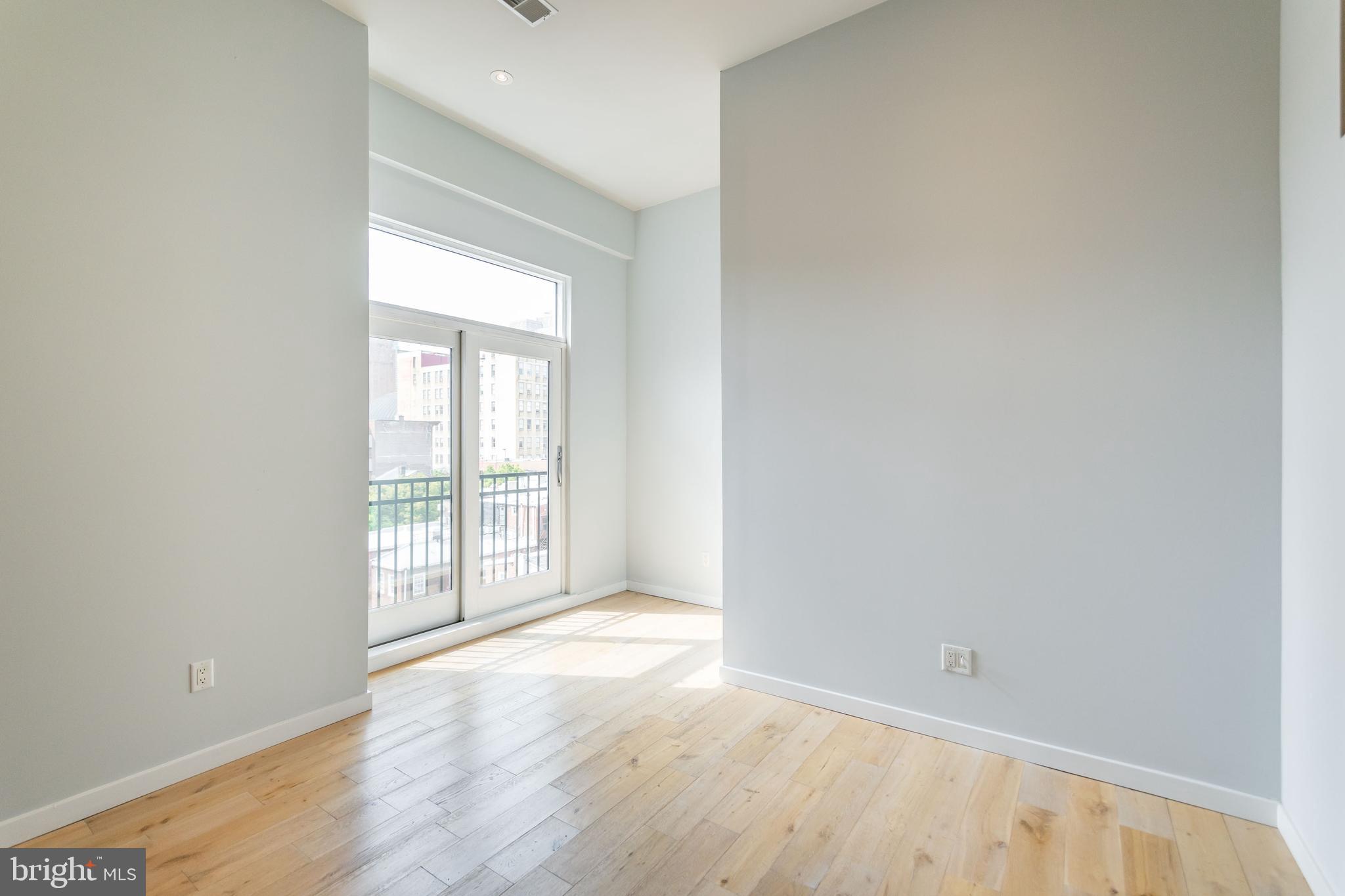412 South 13th Street, Unit 608 Philadelphia, PA 19147 - Photo 6 of 18 an empty room with wooden floor and windows
