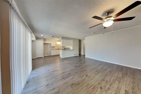 a view of a livingroom with a ceiling fan and wooden floor