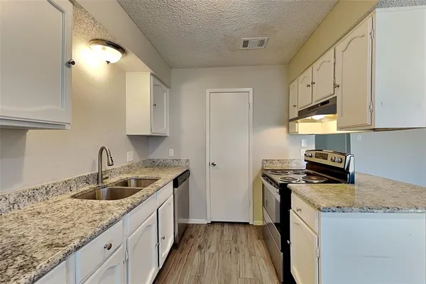 a kitchen with stainless steel appliances granite countertop a sink stove and cabinets
