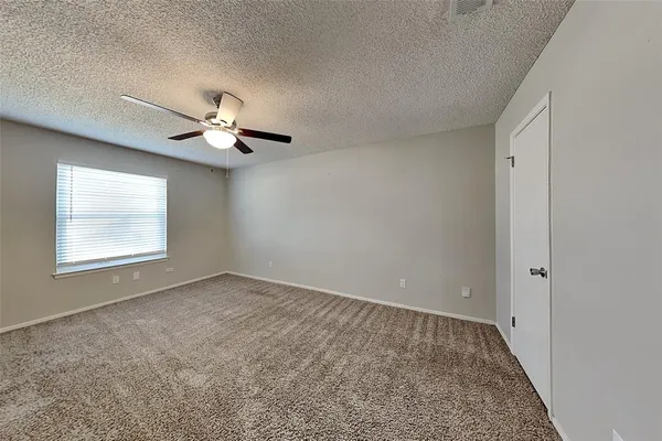 an empty room with a window and a ceiling fan