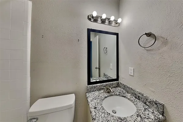 a bathroom with a toilet a sink and mirror