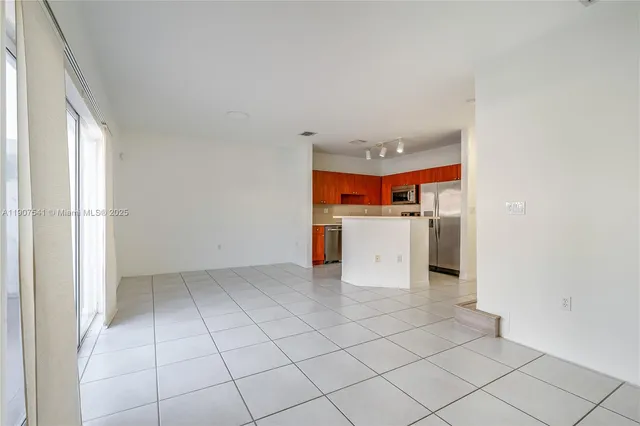 a kitchen with stainless steel appliances granite countertop a refrigerator and a stove