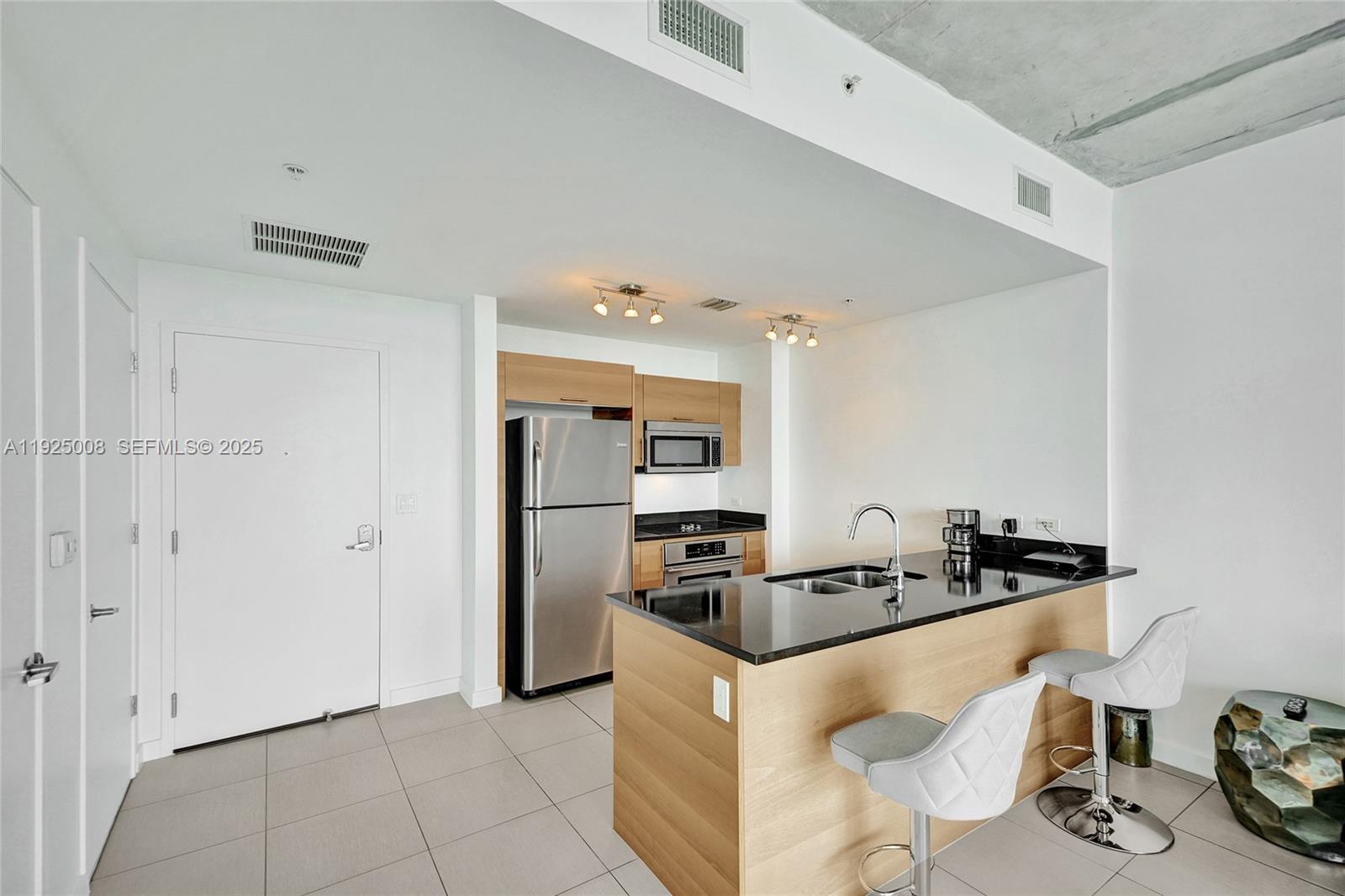3301 Northeast 1st Avenue, Unit H2205 Miami, FL 33137 - Photo 10 of 28 a kitchen with granite countertop a sink and cabinets