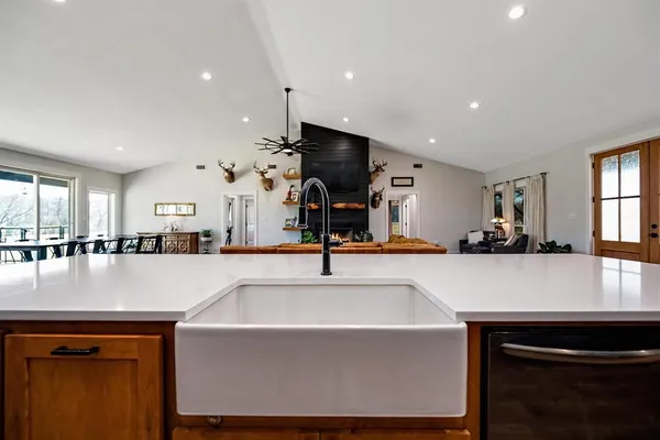 a large kitchen with stainless steel appliances a large counter top a stove and a sink