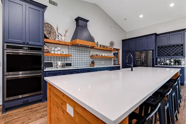 a kitchen with kitchen island a stove and a refrigerator
