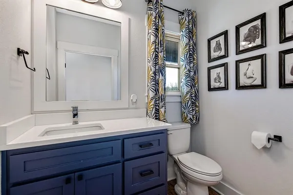 a bathroom with a sink vanity mirror and toilet
