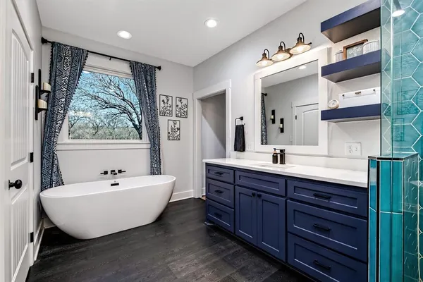 a spacious bathroom with a double vanity sink a mirror and a bathtub