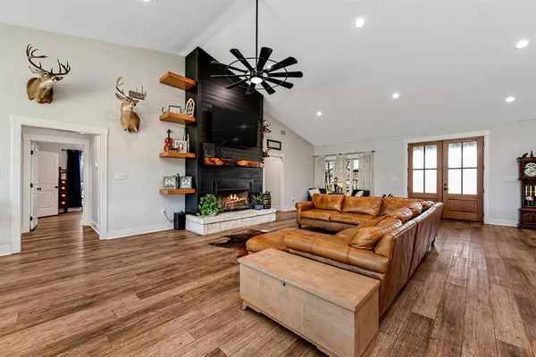a living room with fireplace furniture and a wooden floor