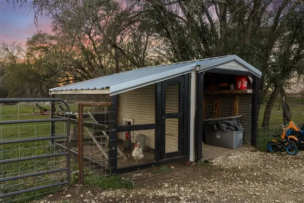 a view of a small house with a large window and potted plants