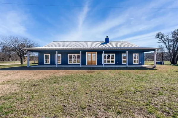 a front view of a house with yard and green space