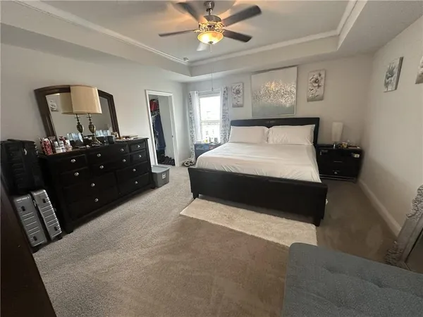 a large bedroom with a large bed and a chandelier