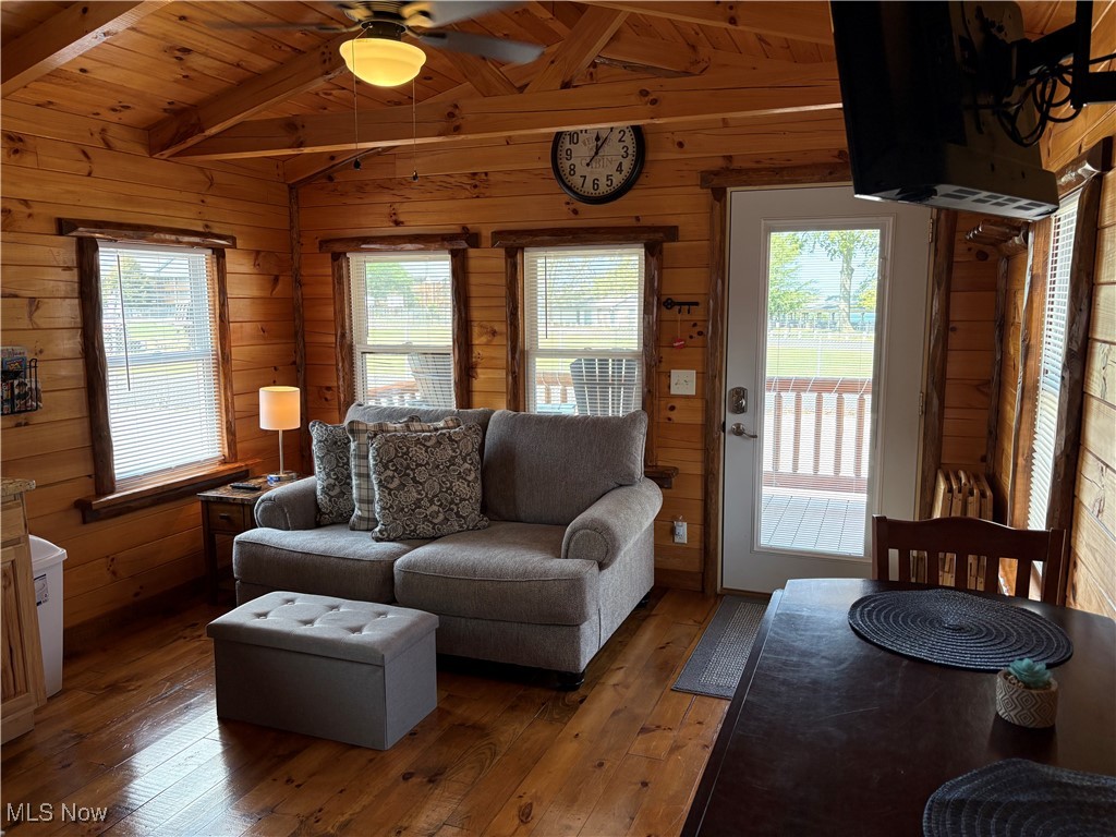 5919 Lake Road West, Unit 7 Ashtabula, OH 44004 - Photo 9 of 29 Living room featuring hardwood / wood-style flooring, wooden walls, wood ceiling, and a ceiling fan