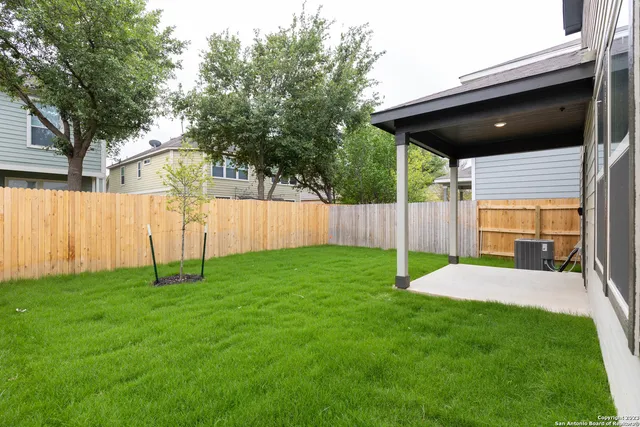 a backyard of a house with table and chairs