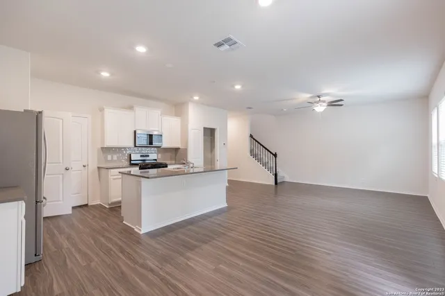 a kitchen with stainless steel appliances a refrigerator and a stove top oven