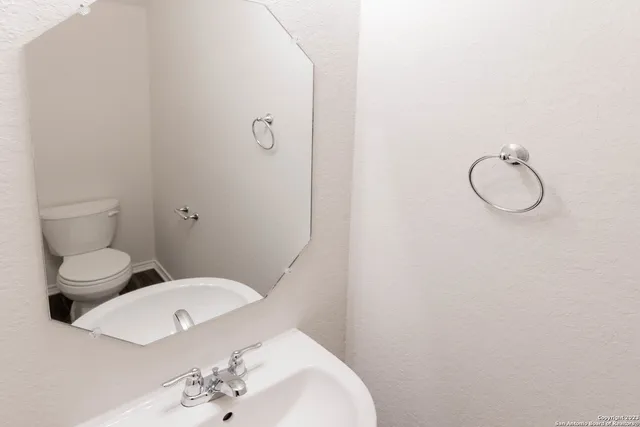 a white toilet sitting next to a bathroom sink