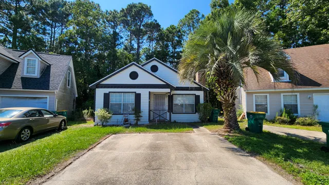 a front view of a house with a garden and trees