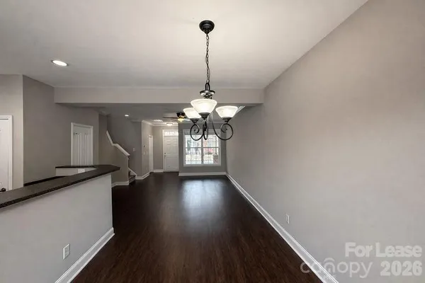 a view of a hallway with wooden floor and chandelier