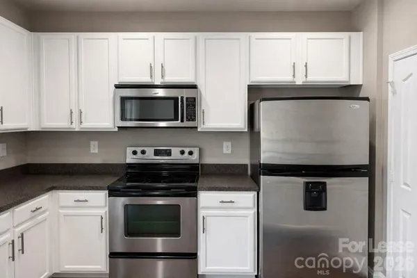 a kitchen with granite countertop a stove and a microwave