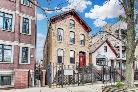 a view of a white house with iron fence