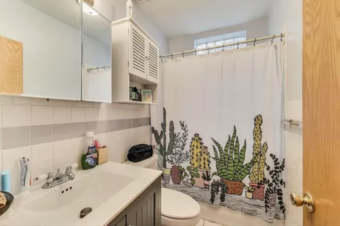a bathroom with a sink a toilet and shower curtain