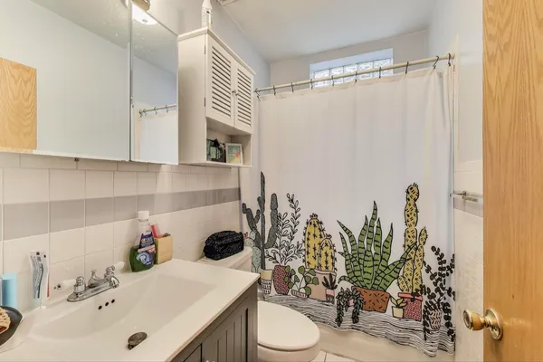 a bathroom with a sink a toilet and shower curtain