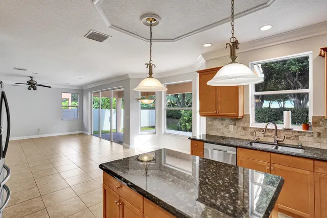 a kitchen with stainless steel appliances granite countertop a sink a stove and a granite counter top
