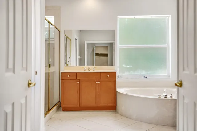 a spacious bathroom with a granite countertop tub sink and mirror