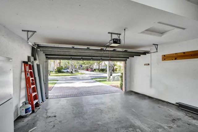 an empty room with wooden floor mirror and windows