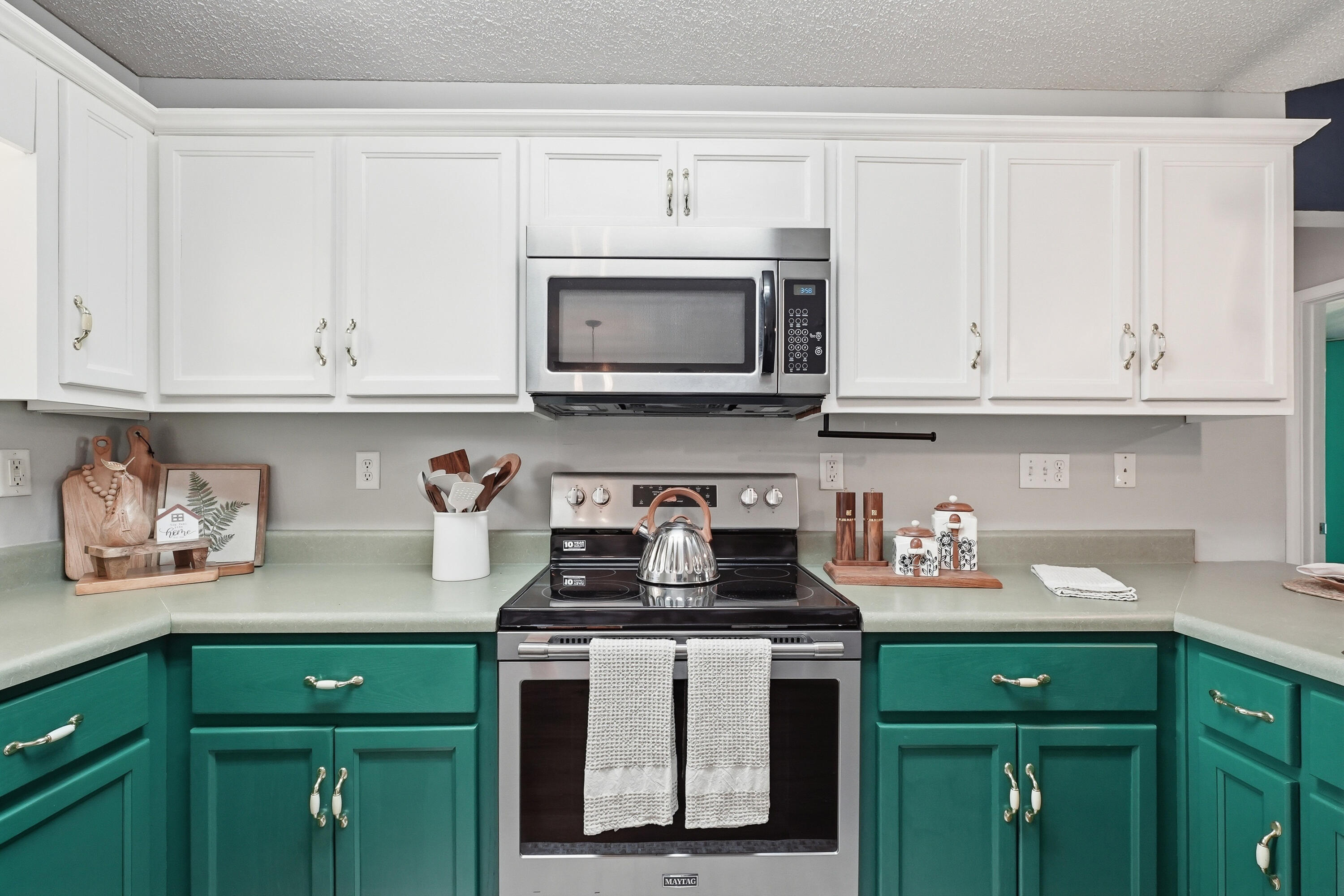 3033 Cabela Lane Crestview, FL 32539 - Photo 9 of 32 a kitchen with stainless steel appliances granite countertop a stove a microwave and cabinets