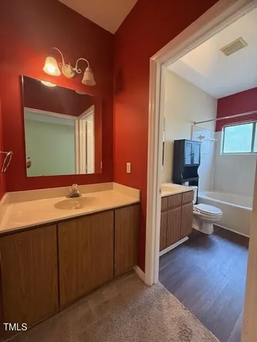 a bathroom with a tub a double vanity sink and mirror