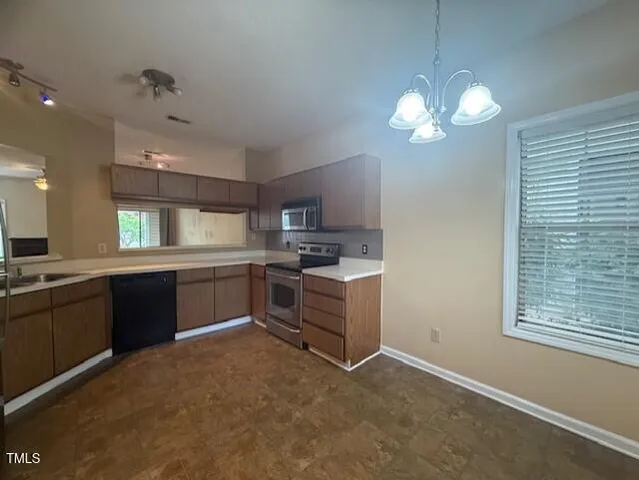 a kitchen with cabinets a center island and stainless steel appliances