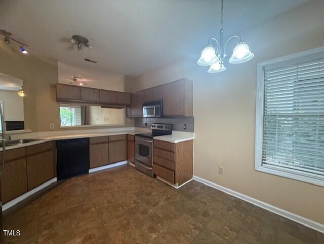 6020 Winterpointe Lane, Unit 103 Raleigh, NC 27606 - Photo 4 of 17 a kitchen with cabinets a center island and stainless steel appliances