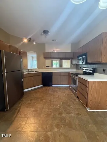 a large kitchen with cabinets and stainless steel appliances