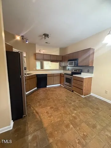 a kitchen with stainless steel appliances granite countertop a refrigerator and a stove top oven