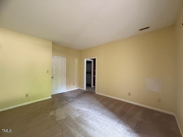 6020 Winterpointe Lane, Unit 103 Raleigh, NC 27606 - Photo 10 of 17 an empty room with closet and wooden door