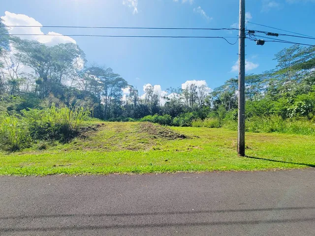 a white house with a yard and a large parking space