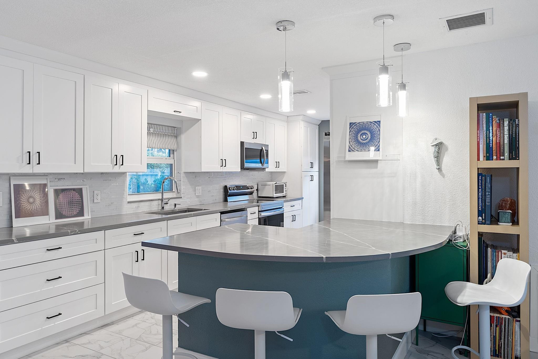22848 Southwest 54th Way Boca Raton, FL 33433 - Photo 11 of 44 a kitchen with stainless steel appliances granite countertop a table chairs sink and cabinets