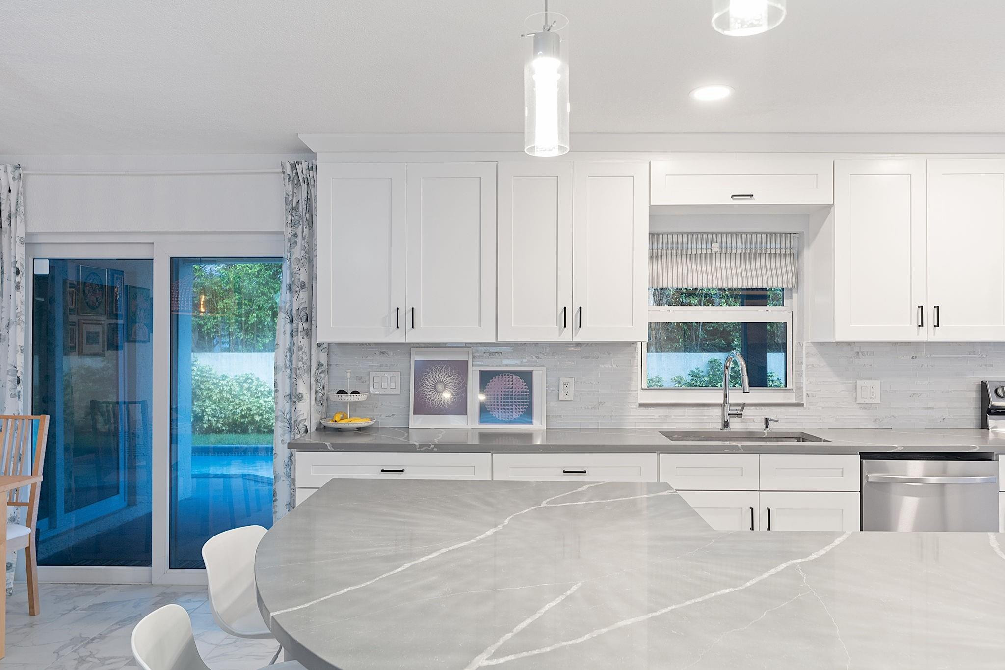 22848 Southwest 54th Way Boca Raton, FL 33433 - Photo 12 of 44 a kitchen with stainless steel appliances kitchen island granite countertop a sink and white cabinets with wooden floor